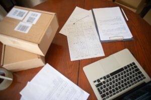 Biuro pracownika zajmującego się Amazon FBA PPWR obowiązkami — laptop z dokumentami opakowaniowymi na biurku