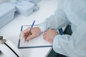Ewidencja BDO kartony opakowania — segregator z dokumentami raportowymi dotyczącymi odpadów opakowaniowych na biurku obok laptopa