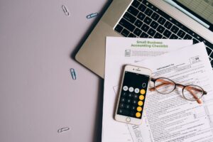 Laptop z otwartym formularzem BDO na biurku, dokumenty dotyczące rocznego rozliczenia BDO i terminu, naturalnym oświetleniu biura