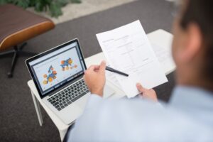 Pracownik biurowy sprawdza faktury KSeF Allegro BDO na laptopie w nowoczesnym polskim biurze