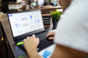 Obsługa BDO Allegro - laptop z formularzami na biurku biznesmena, dokumenty księgowe, naturalne światło