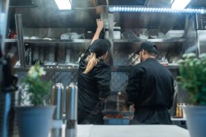 Profesjonalna kuchnia restauracyjna z opakowaniami na wynos — PPWR gastronomia PFAS opakowania zmiana przepisów 2026